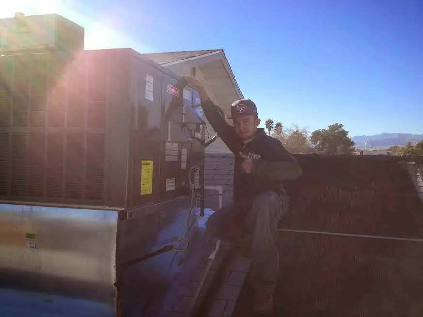 HVAC technician performing Boiler Repair on a rooftop unit in Bellwood